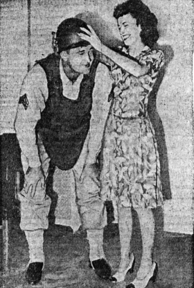 Mrs. Shirley Westcott places helmet on Seargent William O. Harris